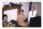 Image of Clara Thomas seated on the floor of a living room beside her husband Morley. An unknown woman is seated at a chair in the left hand side of the frame, December 1967. Clara Thomas Archives & Special Collections, Clara Thomas fonds, F0432, image no. ASC07979.