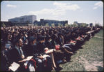 graduating students sitting on a lawn